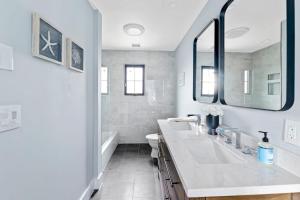 ein weißes Badezimmer mit zwei Waschbecken und einem Spiegel in der Unterkunft Marble & Sun in Hampton Bays
