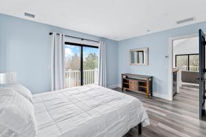 ein weißes Schlafzimmer mit einem Bett und einem Fenster in der Unterkunft Marble & Sun in Hampton Bays + 17 Fotos