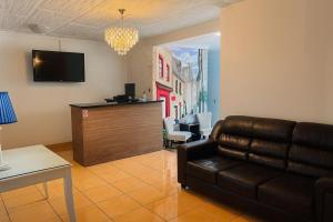 a living room with a couch and a tv at Hotel Verona in San Pedro Sula