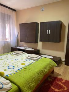 a bedroom with a large bed with a green blanket at Nena in Veliko Gradište