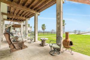 a porch with chairs and a table and a field at Reel Paradise in Bacliff