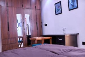 ein Schlafzimmer mit einem Bett, einem Schreibtisch und einem Tisch in der Unterkunft Treasureblue in Suberu Oje
