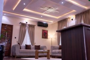 ein Wohnzimmer mit zwei Sofas und einem Fernseher in der Unterkunft Treasureblue in Suberu Oje
