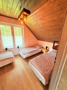 a bedroom with two beds and two windows at 10 osobowy Bania House Okuninka rowerek wodny jacuzzi sauna 1200 m do centrum Okuninki 6 km do Włodawy in Włodawa +36 photos