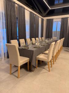 a long table with chairs and wine glasses on it at Casa Daria in Durău