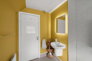 a yellow bathroom with a sink and a mirror at Home in Perth and Kinross in Coupar Angus