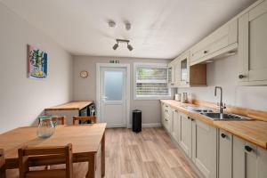 a kitchen with white cabinets and a wooden table at Home in Perth and Kinross in Coupar Angus