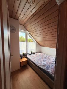 a bed in a room with a wooden ceiling at 10 osobowy Bania House Okuninka rowerek wodny jacuzzi sauna 1200 m do centrum Okuninki 6 km do Włodawy in Włodawa
