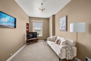 a living room with a white couch and a tv at Home in Perth and Kinross in Coupar Angus