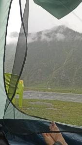 a person sitting in a tent looking out at a mountain at Nomad's Nest Camp in Wāmpor