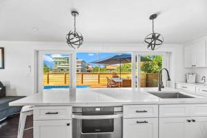 a kitchen with a white counter top and a patio at Poolside Chic by the Sea in Ocean Bay Park