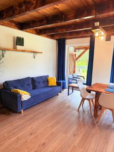 a living room with a blue couch and a table at 10 osobowy Bania House Okuninka rowerek wodny jacuzzi sauna 1200 m do centrum Okuninki 6 km do Włodawy in Włodawa