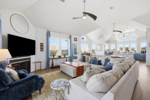 a living room with a large couch and a tv at 5471 - Resting Beach Face in Nags Head +56 photos