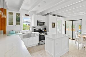 a kitchen with white cabinets and a stove top oven at Seaclusion Gardens in Ocean Beach