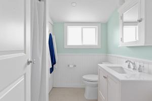 a white bathroom with a toilet and a sink at Seaclusion Gardens in Ocean Beach +21 photos