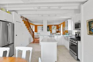 a white kitchen with white cabinets and white appliances at Seaclusion Gardens in Ocean Beach