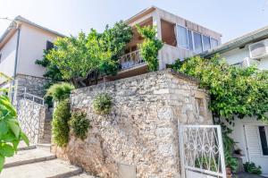 a house with a stone wall and a gate at Rooms Roza in Vrboska +21 photos