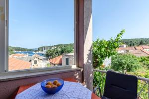 a bowl of fruit on a table in front of a window at Rooms Roza in Vrboska