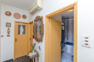 a hallway with a yellow door and a doorway to a bathroom at Rooms Roza in Vrboska