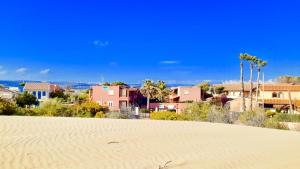 een uitzicht op een strand met huizen en palmbomen bij Le Dune Residence in Santa Maria Del Focallo