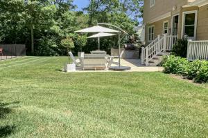 a lawn with two chairs and an umbrella at Hamptons Hideaway in Hampton Bays