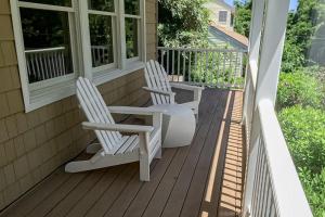 two white chairs sitting on the porch of a house at Hamptons Hideaway in Hampton Bays +26 photos