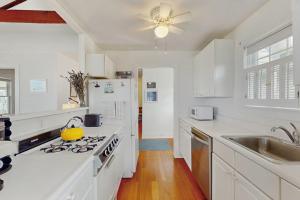 a white kitchen with a stove and a sink at North Fork Waterfront Gem in East Marion
