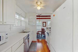 a kitchen with white cabinets and a ceiling fan at North Fork Waterfront Gem in East Marion +20 photos