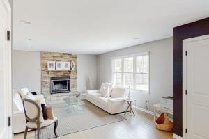 a living room with a white couch and a fireplace at Hamptons Hideaway in Hampton Bays