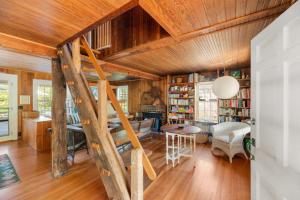 a living room with wooden ceilings and a spiral staircase at Seaside Escape on Huron in Ocean Beach