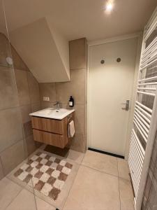 a bathroom with a sink and a checkered floor at Salty dunes in Noordwijk +16 photos