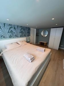 a bedroom with a large bed with two towels on it at Salty dunes in Noordwijk
