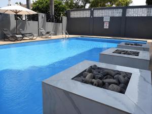 a swimming pool with rocks in the middle of it at THE POOL LABONE in Accra