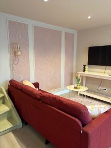 a living room with a red couch and a tv at Salty dunes in Noordwijk