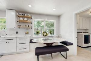 a white kitchen with a table and a sink at Lake Grove Retreat in Conroe