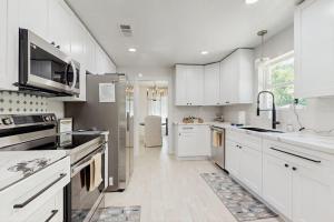a large white kitchen with white cabinets and appliances at Lake Grove Retreat in Conroe