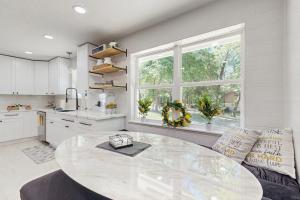 a large white kitchen with a large glass table at Lake Grove Retreat in Conroe