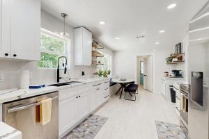a kitchen with white cabinets and a table at Lake Grove Retreat in Conroe