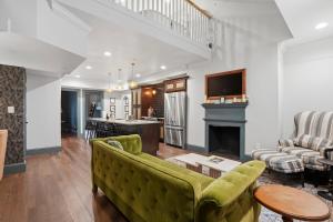 a living room with a green couch and a fireplace at The Gas Lamp Hotel in Philadelphia