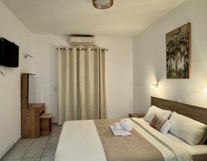 a bedroom with a large bed and a television at Avlή Apartments I in Kamári +21 photos