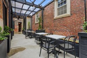a patio with tables and chairs and a brick wall at The Gas Lamp Hotel in Philadelphia