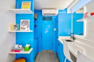 a blue bathroom with a sink and blue cabinets at Blueberry Container at EADO Juicebox in Houston +20 photos