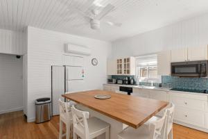 a kitchen with a wooden table and white appliances at 10 Cayuga in Ocean Bay Park