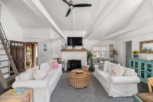 a living room with white furniture and a fireplace at 15 Seneca in Ocean Bay Park