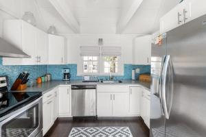 a kitchen with white cabinets and a stainless steel refrigerator at 15 Seneca in Ocean Bay Park