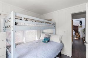 a white bedroom with a bunk bed and a window at 15 Seneca in Ocean Bay Park +17 photos