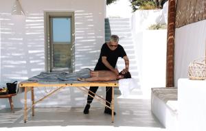 a man waxing a persons legs on a table at Thimari Lodge in Fira +38 photos