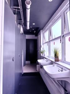 a bathroom with two sinks and two windows at Hangover Hotel - Seafront 8 in Brighton & Hove
