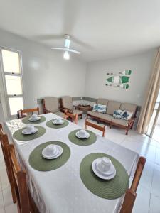 a dining room table with a white and green table cloth at Praia Morro Katia apartamentos - Edificio Porto Belo in Guarapari