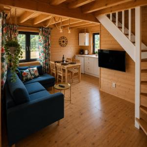 a living room with a blue couch and a kitchen at Osada Międzywodzie in Międzywodzie